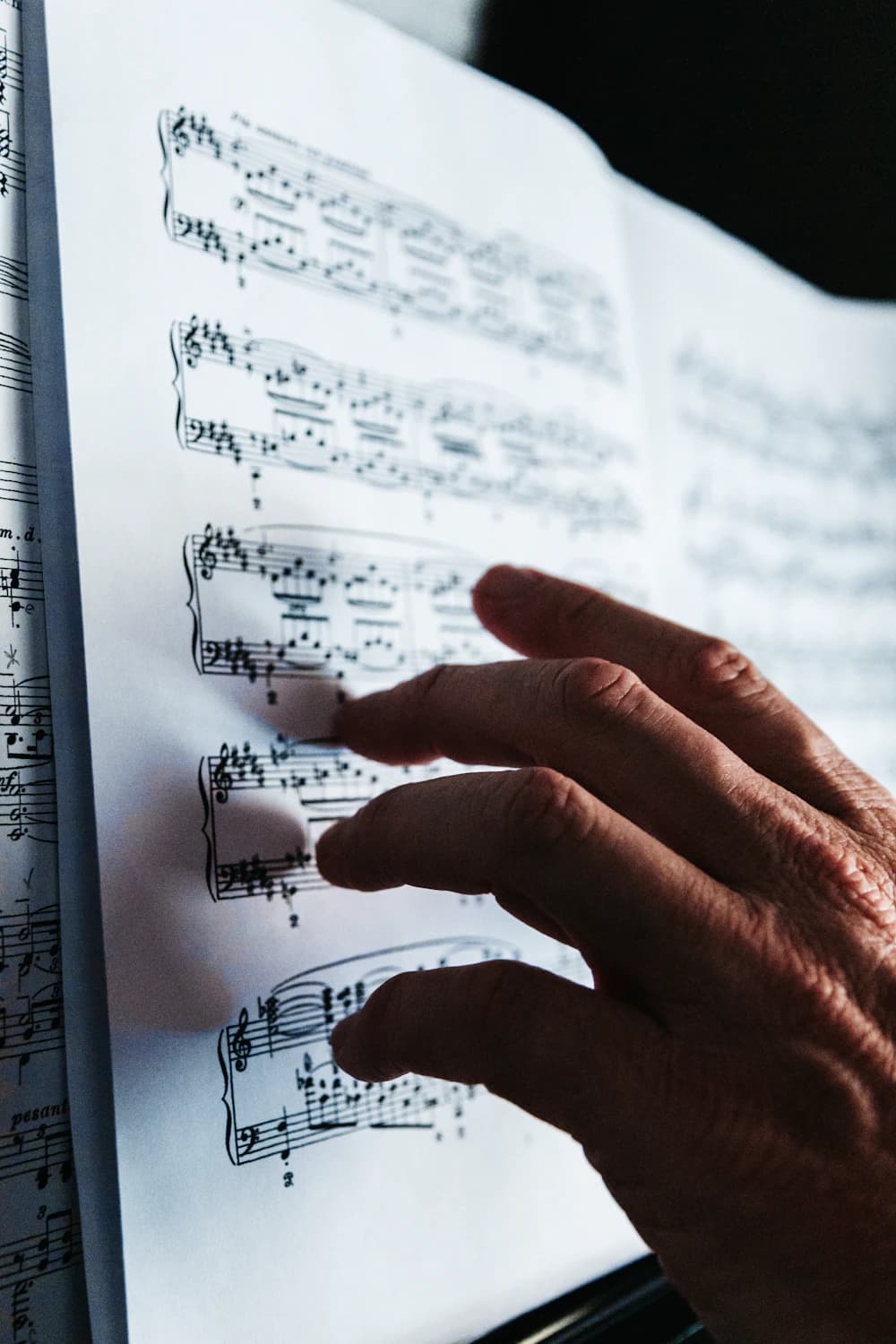 Hand following notes on a page of sheet music